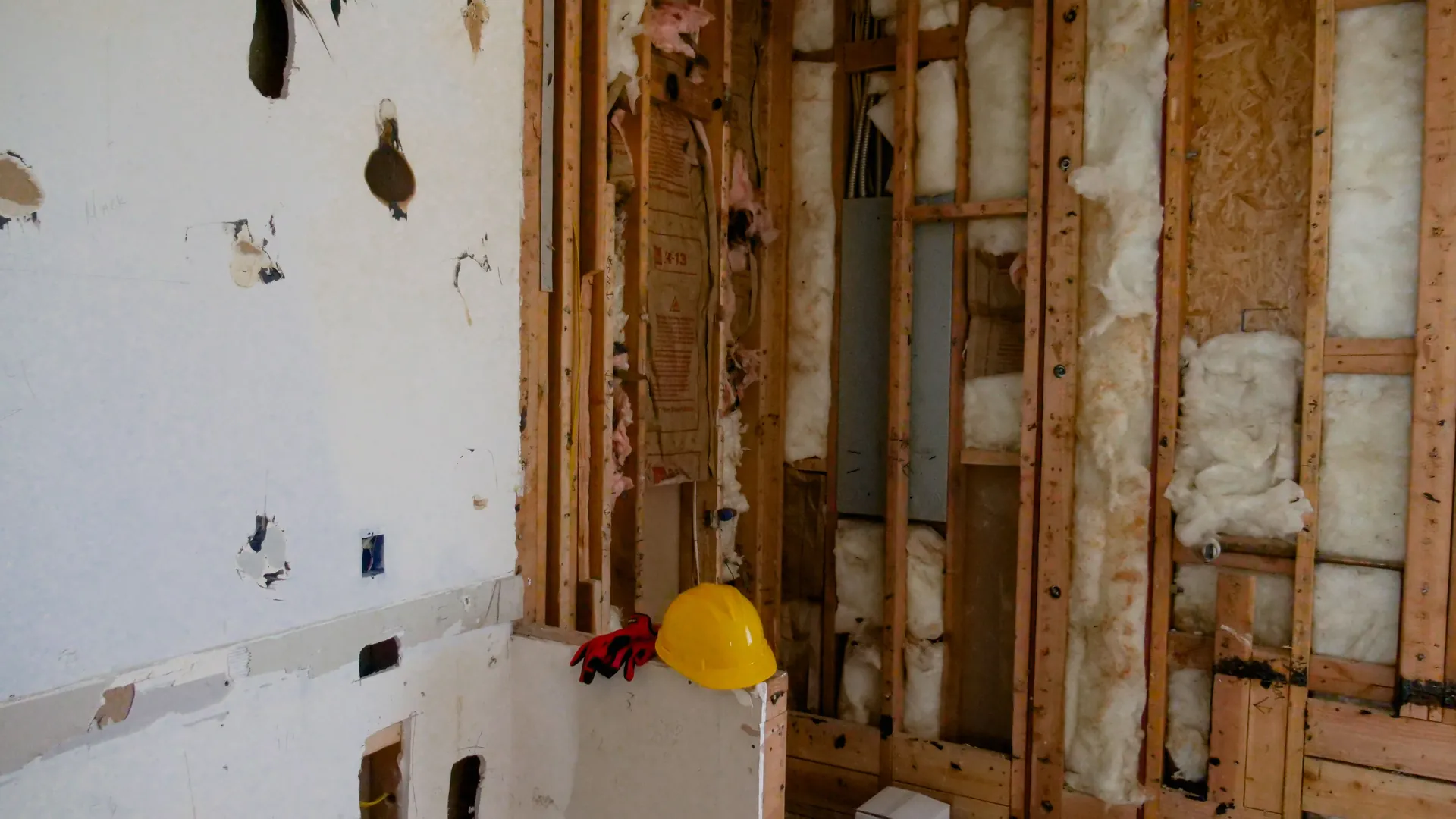 Interior wall opened to the studs and insulation after drywall removal